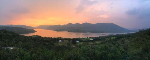 a view of a body of water at sunset at The Green Gate Resort Mulshi in Pune