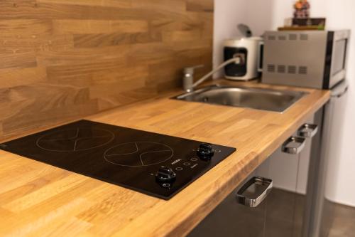 eine Küche mit einer Arbeitsplatte mit einer Spüle und einer Theke von 6 dx in der Unterkunft Rezidence Hadovitá in Prag