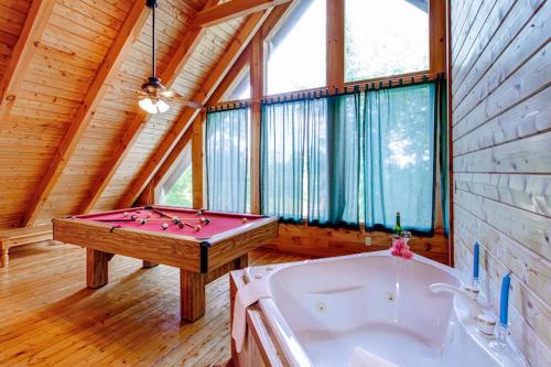 a bathroom with a pool table and a tub at Country Hideaway in Sevierville