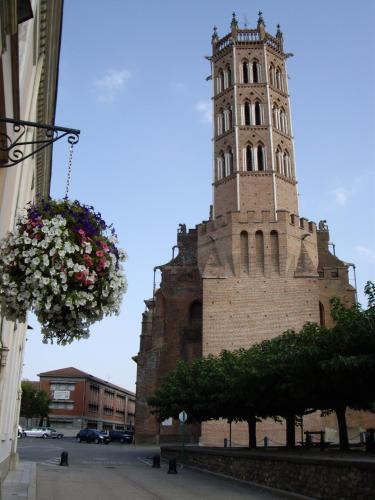 a building with a clock tower with a hanging basket of flowers at Spacieux Appartement Lumineux Cœur De Ville in Pamiers
