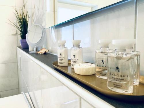 a bathroom counter with bottles of soap and a mirror at Baden Airpark Family Apartment in Hügelsheim