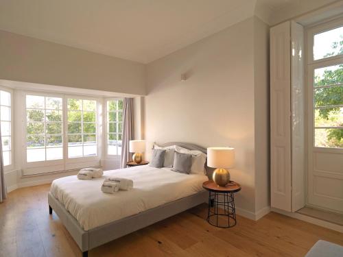 FLH Seaside Luxury House in Porto في بورتو: غرفة نوم بسرير مع مصباحين ونوافذ اثنين