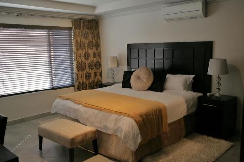 a bedroom with a large bed and a window at Villa Moyal in Johannesburg