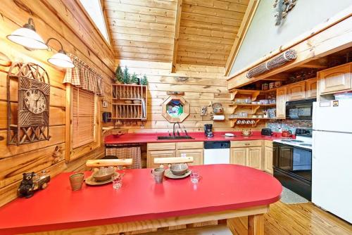 a red table in a kitchen with wooden walls at Sticks and Stones in Sevierville