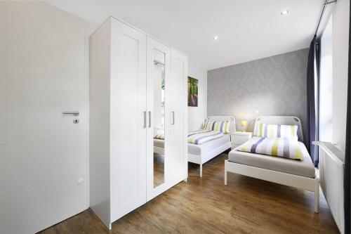 Habitación blanca con 2 camas y 2 sillas en Apartment End en Heidelberg