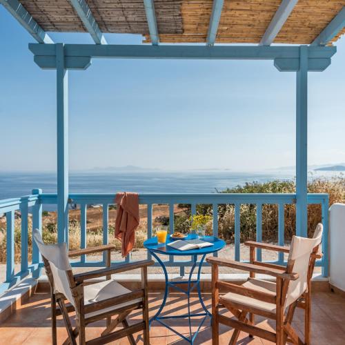 a table and chairs on a balcony with a view of the ocean at Asterias House in Donoussa