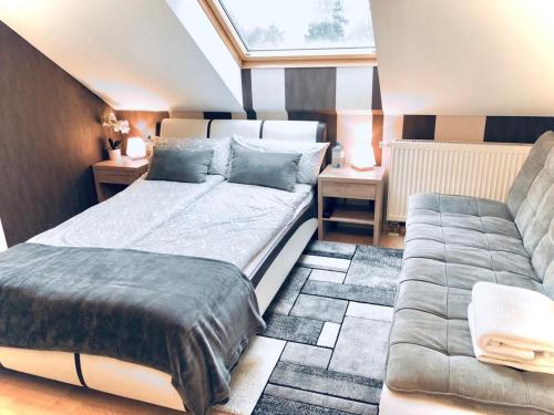 ein Schlafzimmer mit einem Bett und einem Sofa in der Unterkunft Baden Airpark Family Apartment in Hügelsheim