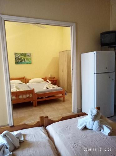 a room with two beds and a refrigerator at Sofia Rooms in Loutra Edipsou