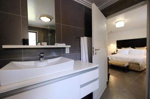a bathroom with a sink and a bed at Villa Moyal in Johannesburg