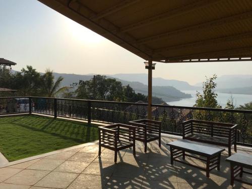 a group of benches on a balcony with a view at The Green Gate Resort Mulshi in Pune