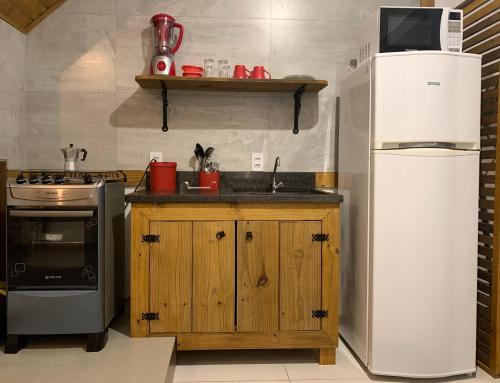 a kitchen with a white refrigerator and a sink at BeMyGuest Floripa in Florianópolis