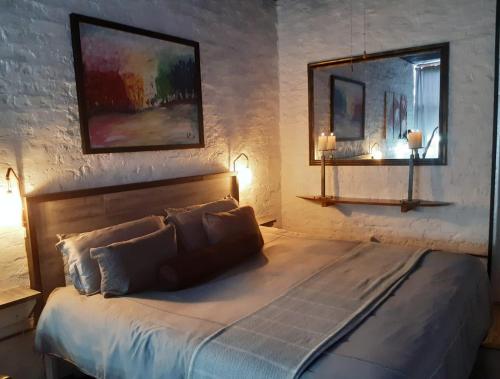 a bedroom with a bed with two lamps and a mirror at King Protea Self Catering Flat in Mossel Bay