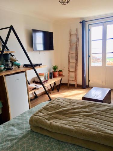 a bedroom with a bed and a tv and a room with a window at The Azores Homestead - Terceira in Santa Bárbara