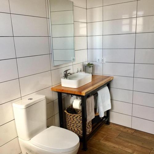a bathroom with a sink and a toilet at The Azores Homestead - Terceira in Santa Bárbara
