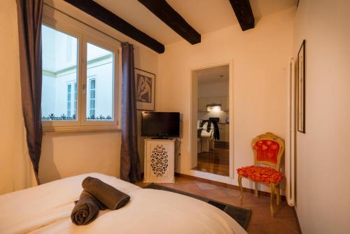 - une chambre avec un lit, une fenêtre et une télévision dans l'établissement Il Florino, à Merano