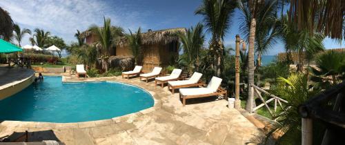 een zwembad met ligstoelen en een resort bij El Mirador de Vichayito in Vichayito