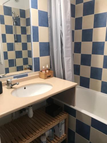 une salle de bain avec un lavabo, un miroir et une baignoire dans l'établissement Maison Loubière, à Hyères