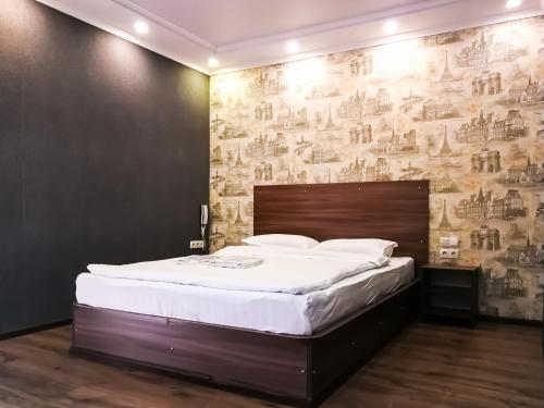 ein Schlafzimmer mit einem großen Bett mit Wandbild in der Unterkunft Salut Hotel in Bischkek