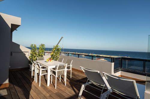 een balkon met een tafel en stoelen en de oceaan bij Pier 31 in Telde