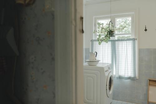 a washing machine in a bathroom with a window at Lillstugan in Vöyri