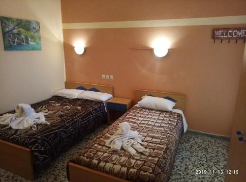 a hotel room with two beds with towels on them at Sofia Rooms in Loutra Edipsou