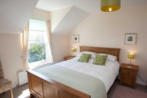 a bedroom with a large white bed and a window at Killinallan Cottage in Port Charlotte