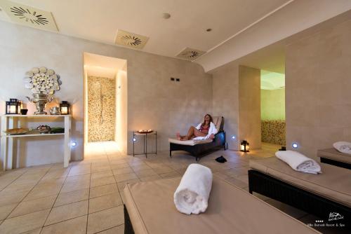 a woman sitting in a chair in a living room at Hotel Villa Durrueli Resort & Spa in Ischia