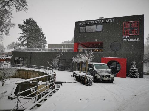 a car parked in front of a building in the snow at cité impériale ye in Mettet