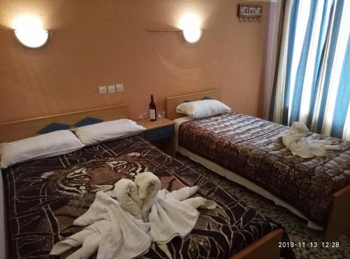 a hotel room with two beds with towels on the floor at Sofia Rooms in Loutra Edipsou
