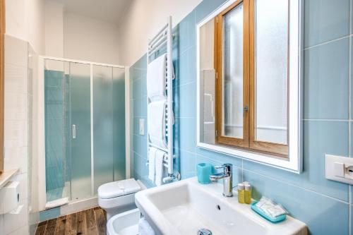 La salle de bains est pourvue d'un lavabo, de toilettes et d'un miroir. dans l'établissement La Residenza Suites, à Rome