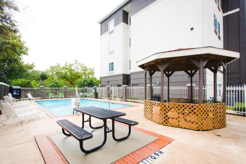 a picnic table and a gazebo next to a pool at Palacio Royale Inn Signature Katy in Katy