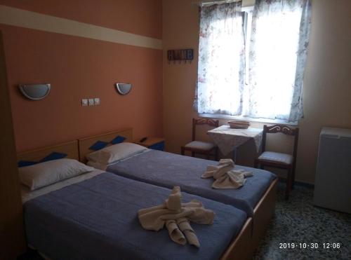 two beds in a room with towels on them at Sofia Rooms in Loutra Edipsou