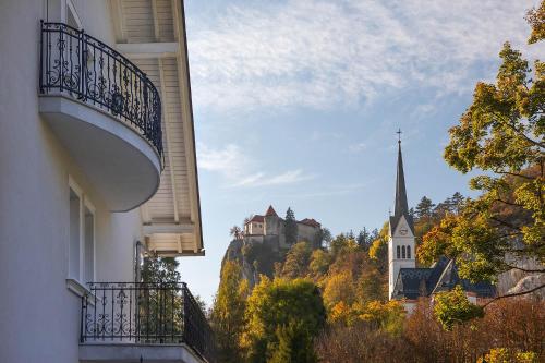 a castle on top of a hill with a church at Apartment Vila Pavlovski in Bled