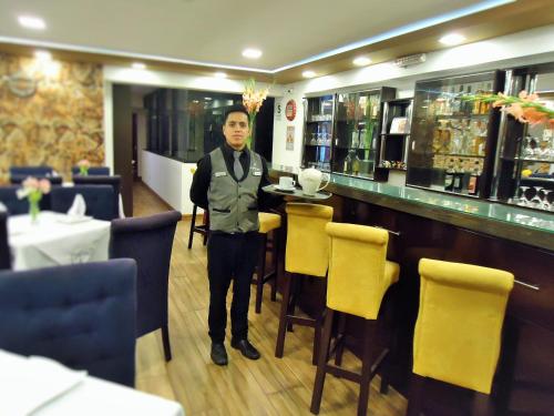 a man standing at a bar in a restaurant at San Francisco Cusco Hotel in Cusco