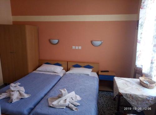 two beds with towels on them in a bedroom at Sofia Rooms in Loutra Edipsou