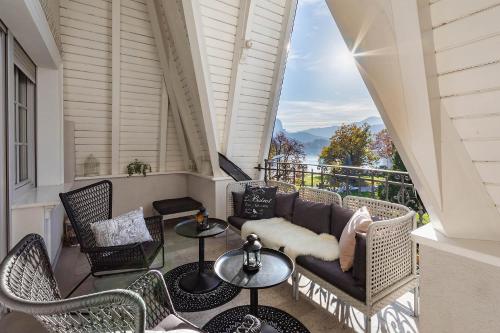 a balcony with a couch and tables and chairs at Apartment Vila Pavlovski in Bled