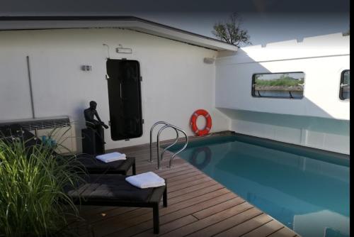 a swimming pool in a house with a swimming pool at B&B Droomboot in Oudenburg