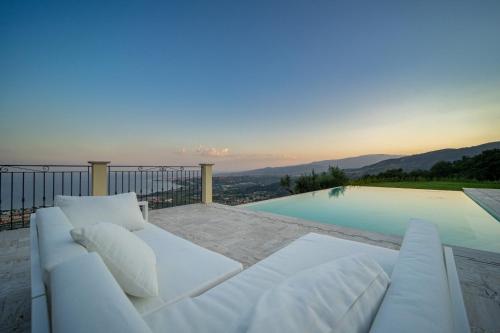 a white couch sitting next to a swimming pool at Villa le Fontanelle in Gasperina