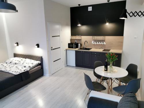 a bedroom and kitchen with a bed and a table at Charming Apartment in The City Centre, Łódź in Łódź
