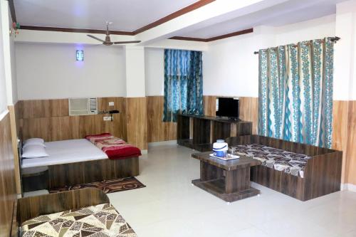 パチマーヒにあるJain Residencyのベッドとソファとテーブルのある部屋