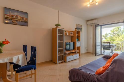 a room with a bed and a table and a television at Apartmani Juraj in Zavalatica