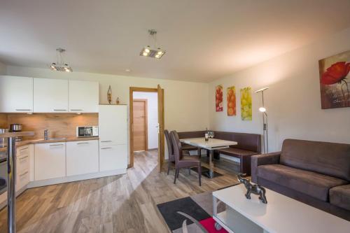 a kitchen and living room with a couch and a table at Panoramaresidenz Scheffau am Wilden Kaiser in Scheffau am Wilden Kaiser
