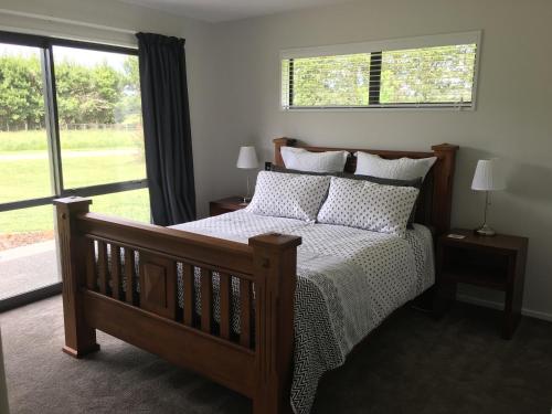 um quarto com uma cama e uma grande janela em Sandy Acre em North Loburn