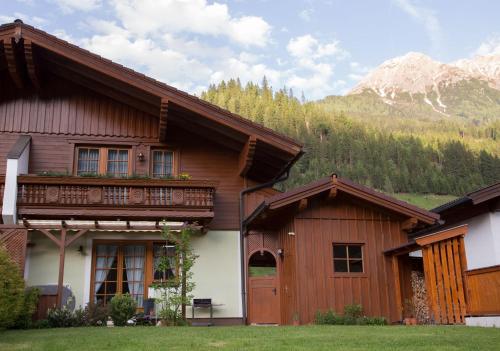 a wooden house with a balcony and a mountain at Ferienhaus Kleinarl in Kleinarl