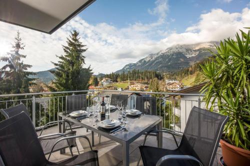 a patio with a table and chairs on a balcony at Panoramaresidenz Scheffau am Wilden Kaiser in Scheffau am Wilden Kaiser
