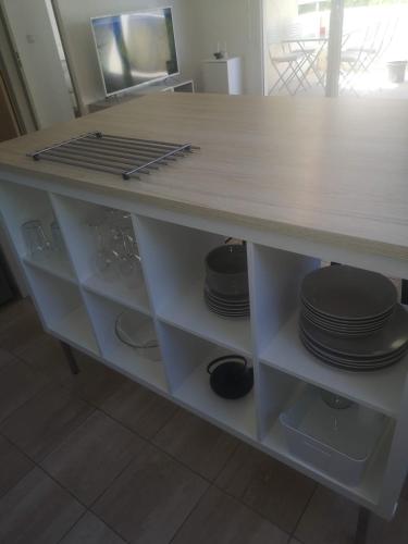 un comptoir avec des assiettes et de la vaisselle dans l'établissement Charmant F2 Port Marianne (15 Min Plages/Centre-ville), à Montpellier