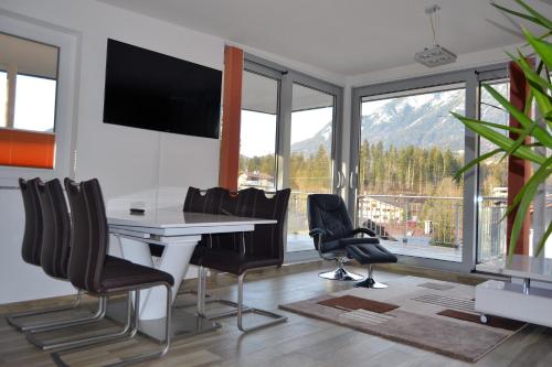 a dining room with a table and chairs and a large window at Panoramaresidenz Scheffau am Wilden Kaiser in Scheffau am Wilden Kaiser