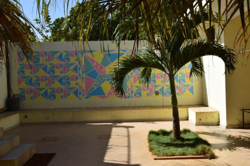 a palm tree in front of a colorful wall at Villa Du Soleil Ngaparou in Ngaparou