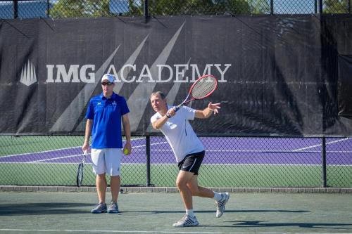 a woman swinging a tennis racket on a tennis court at Legacy Hotel at IMG Academy in Bradenton