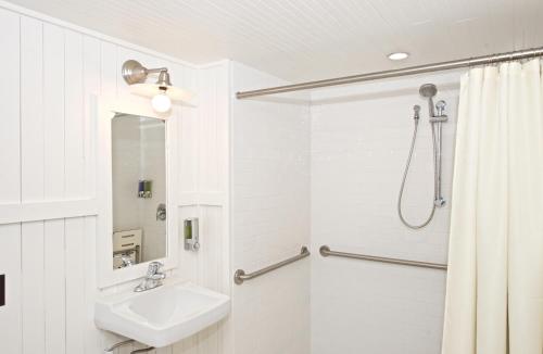 a white bathroom with a sink and a shower at Curry Village in Curry Village